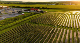 A large solar panel array next to a working field