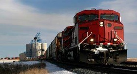 Train moving down a track after a stop at a grain elevator