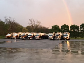 A cool shot of a rainbow arcing over the New-Life Mills feed trucks.