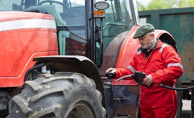 Farmer filling tractor with red dye diesel